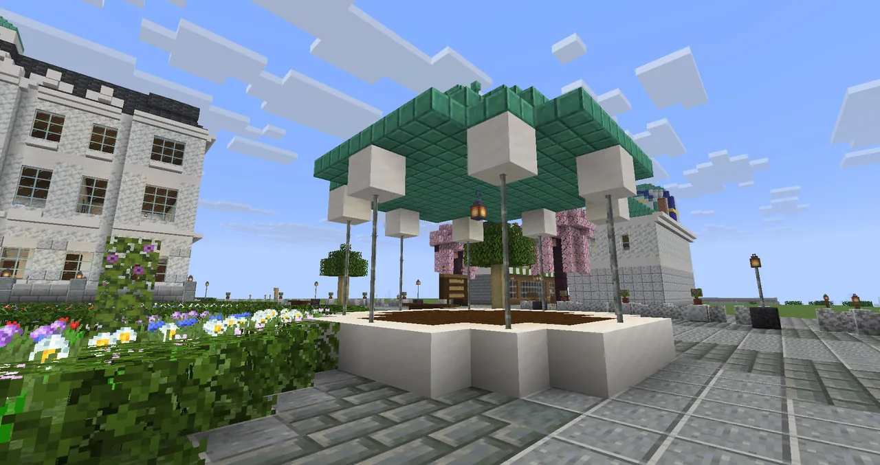 The bandstand on the square, the white town hall behind, flowers and cherry trees.